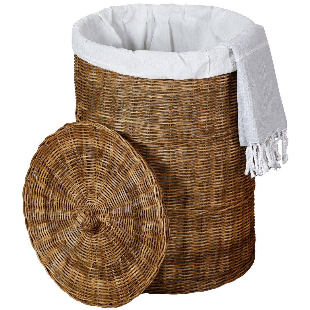Dunkelbrauner Rattan-Wäschekorb mit hellem Wäschebeutel, weißem Fransentuch und abgenommenem rundem Deckel