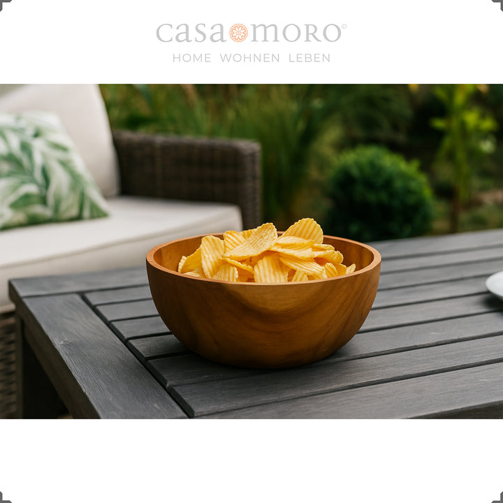 Dekoschale mit Chips auf dunklem Gartentisch