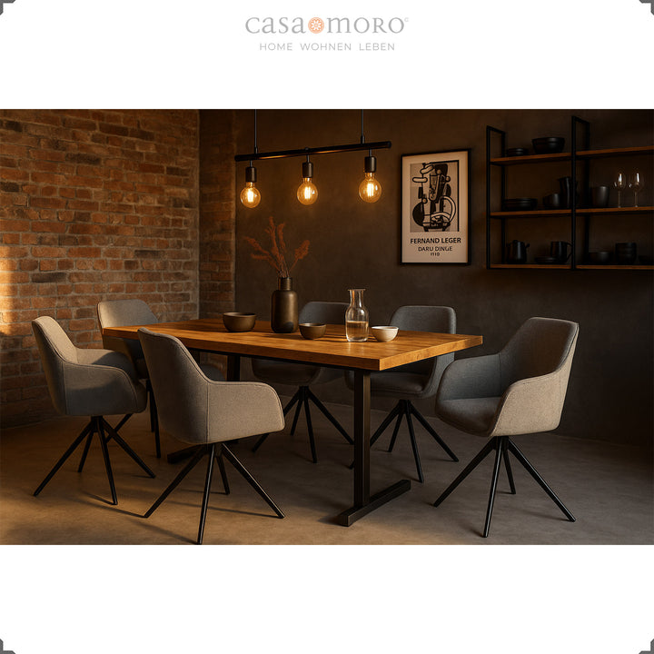 Sechs 360° drehbare Polsterstühle mit Armlehnen in Grau an einem Holztisch in modernem Esszimmer mit Backsteinwand und stimmungsvoller Beleuchtung